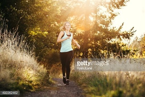 A young adult woman runs along a dirt path in a forest park, the sun... - A young adult woman runs along a dirt path in a forest park, the sun... -   18 fitness Photoshoot forest ideas